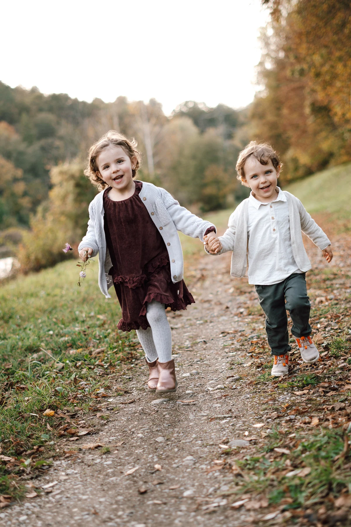 Zwei lachende Kinder laufen gemeinsam durch die Natur