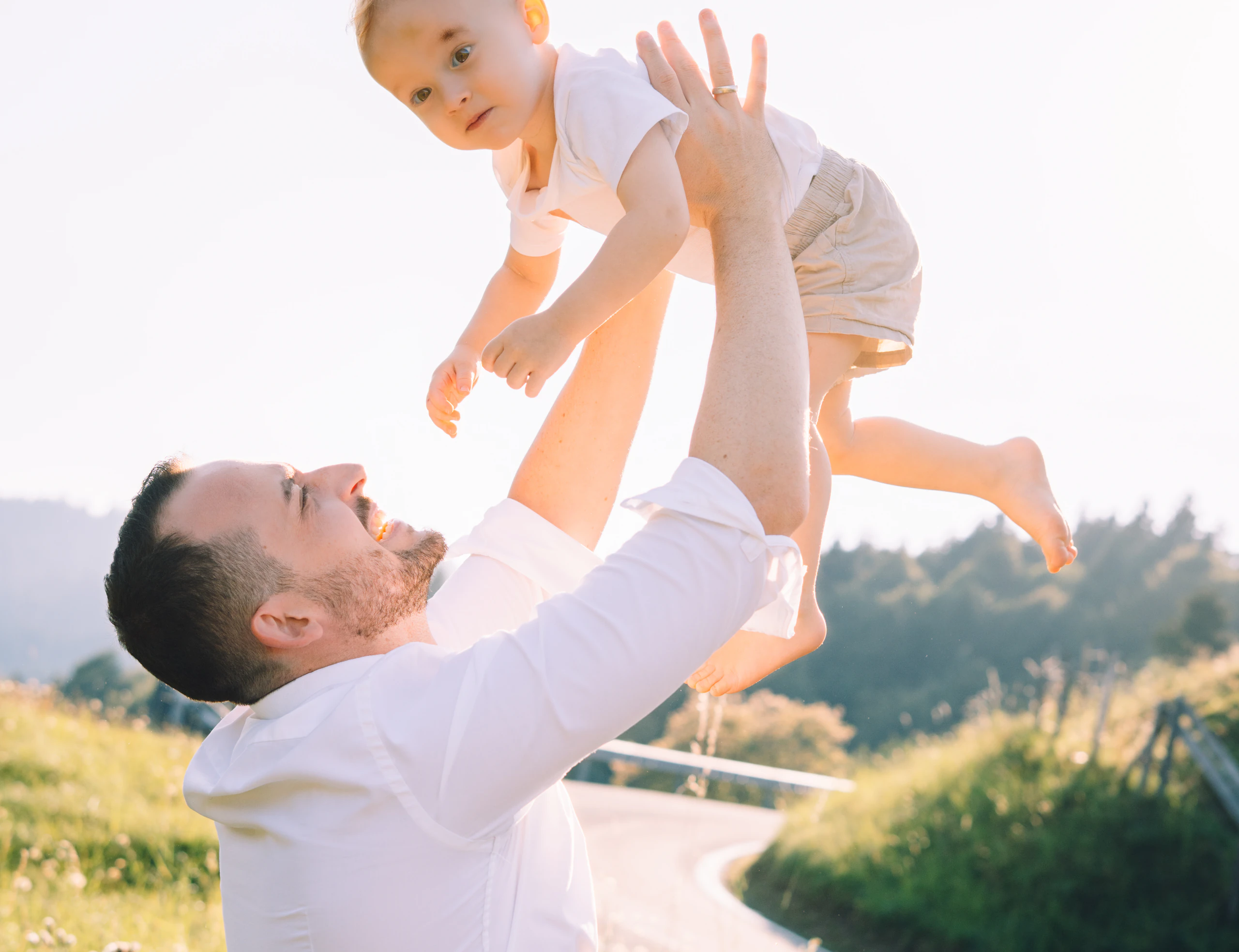 Vater hebt sein Baby im warmen Abendlicht hoch